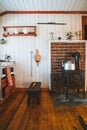 Inside shot of a cozy house with a teapot on the wood oven next to a small chair in the kitchen