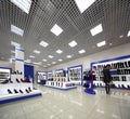 Inside spacious shoes shop with models on shelves Royalty Free Stock Photo