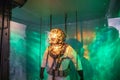 Inside of the USS Alabama Battleship with glass case filled with a underwater diving suit and a green lights at USS Alabama