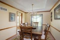 Inside view of a cozy dining room with a wooden table, chairs, and a chandelier