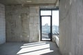 An inside view of an empty newly constructed apartment flat without repair with a window installed in a newly built erected