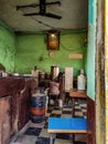 Inside view of Old Indian dirty abandoned hotel kitchen, gods photo and clock hanging on pistachio color painted wall. Gas Royalty Free Stock Photo