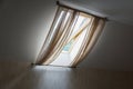 Inside view of opened rooftop window covered with curtains. Royalty Free Stock Photo