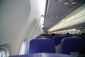 The inside view of the plane That shoots from the back with blue seats that are flying and traveling to destinations.