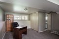 Inside view of a room with a working desk, wooden cabinet, and windows