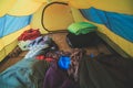 An inside view of tent, process of camping in fall or spring forest field, setting a tent covered