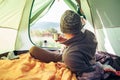 Inside view from tent. Traveler looks on mountain hills panorama