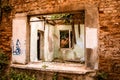 Window of an abandoned tumbledown house, uninhabitable condition, build with refractory clay firebricks, stays with wooden frames