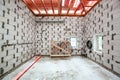 Inside view of working process of building house with wall made from foamed concrete block and wooden platform, electrical cables