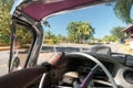 Inside of a vintage pink classic american car in Cuba. driver holds the steering wheel of old car with his hand. Varadero