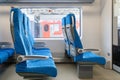 Interior of the passenger train with empty blue fabric seats Royalty Free Stock Photo