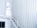 Inside white modern cutting-edge shipping container construction office building with white iron staircase leads up to the glass. Royalty Free Stock Photo