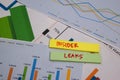 Insider Leaks write on sticky note isolated on wooden table. stock market concept