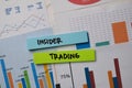 Insider Trading write on sticky notes with graphic on the paper isolated on office desk