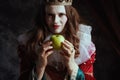 insidious medieval queen in red dress with green apple