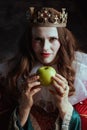 insidious medieval queen in red dress with green apple