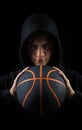 Insolent hooded boy holding basketball