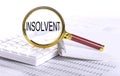 INSOLVENT word through magnifying glass on keyboard on the chart