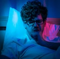 Insomnia sleepless man having problem sleeping in late night with alarm clock telling late night time on his bed Royalty Free Stock Photo