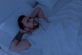 Insomnia and sleeplessness concept. Depressed man unable to sleep, lying in bed, looking up and contemplating Royalty Free Stock Photo
