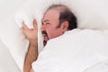 Insomniac clutching at his pillow in desperation Royalty Free Stock Photo