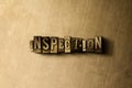 INSPECTION - close-up of grungy vintage typeset word on metal backdrop