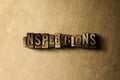 INSPECTIONS - close-up of grungy vintage typeset word on metal backdrop