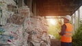 The inspector checks the pressed garbage at the waste recycling plant, waste recycling, sunset