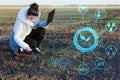 An inspector farmer with a laptop collects data on the field for subsequent analysis of plant growth and identify deficiencies to