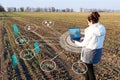 An inspector farmer with a laptop collects data on the field for subsequent analysis of plant growth and identify deficiencies to Royalty Free Stock Photo