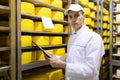 Inspector makes notes in the sheet at the cheese warehouse Royalty Free Stock Photo