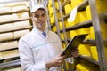 Inspector makes notes in the sheet at the cheese warehouse Royalty Free Stock Photo