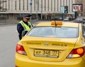 The inspector of traffic police checks the documents of a taxi driver in Central Moscow.