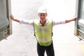 Inspector worker who wears a safety helmet and vest opens the container and checking the quality of cargo