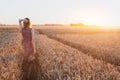 Inspiration or waiting concept, happy beautiful young woman in sunset field Royalty Free Stock Photo