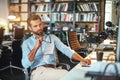 Inspiration. Young bearded businessman holding eyeglasses and thinking about something while sitting in modern office