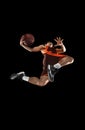 Young professional basketball player in action, motion isolated on black background, look from the bottom. Concept of Royalty Free Stock Photo