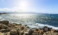 Inspirational beautiful mountains landscape with sea, coast, beach and rocks, high mountains in background at sunrise on