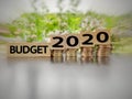inspirational and conceptual - budget 2020 on wooden blocks with coins stack  in blurred motion background Royalty Free Stock Photo