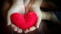 inspirational love concept - image of red heart shaped pillow on kid& x27;s hands in vintage background