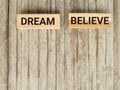 Inspirational and Motivational Concept - DREAM BELIEVE text background. Stock photo.