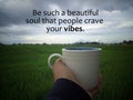 Inspirational motivational quote - Be such a beautiful soul that people crave your vibes. With person holding coffee cup in field. Royalty Free Stock Photo