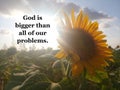 Faith inspirational quote - God is bigger than all of our problems.On nature background of the sun shine behind sunflower.