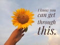 Inspirational motivational quote - I know you can get through this. With background of bright blue sky and sunflower in hand. Royalty Free Stock Photo