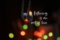 Inspirational motivational quote - Listening is an act of love. With earphone standing together on colorful light bokeh background