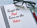 Phrase forget the past focus on the future written on notebook with a pen.