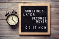 Inspirational motivational quote Sometimes later becomes never. Do it now words on a letter board on wooden background near Royalty Free Stock Photo