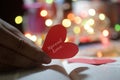 Inspirational motivational quote - Spread love. With red heart in hand. Valentine day card concept on colorful bokeh lights