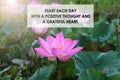 Inspirational motivational quote - Start each day with a positive thought and a grateful heart. With red pink lotus flowers.