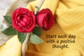 Inspirational motivational quote - Start each day with a positive thought. With two beautiful red roses blossom decoration. Royalty Free Stock Photo